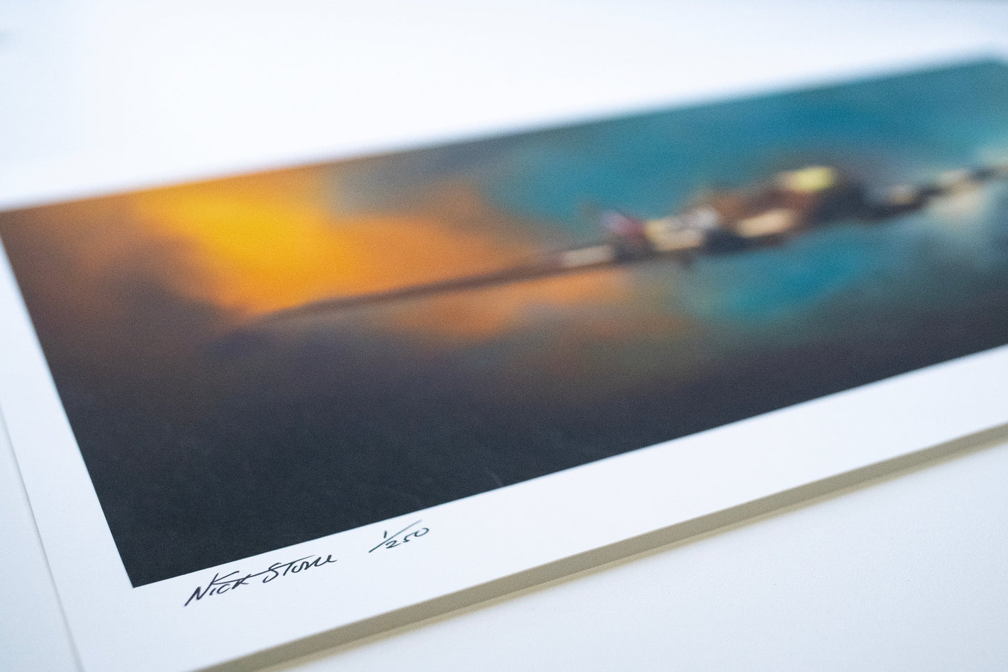 A painting of a Spitfire fighter plane against a blue and orange sky